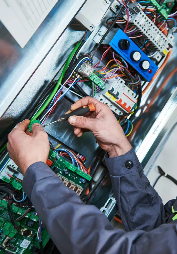 shutterstock_1249449115 A man is working on an electrical panel.